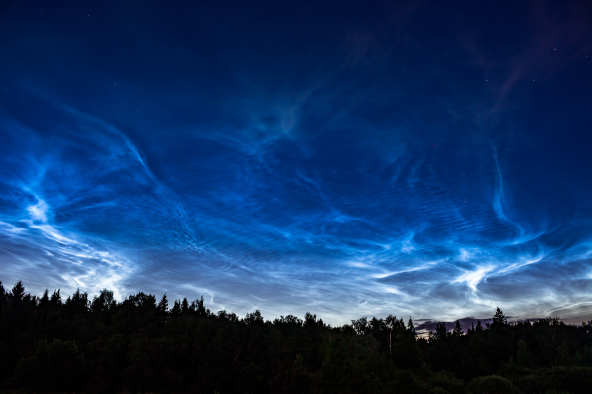 Lysende natteskyer på himlen